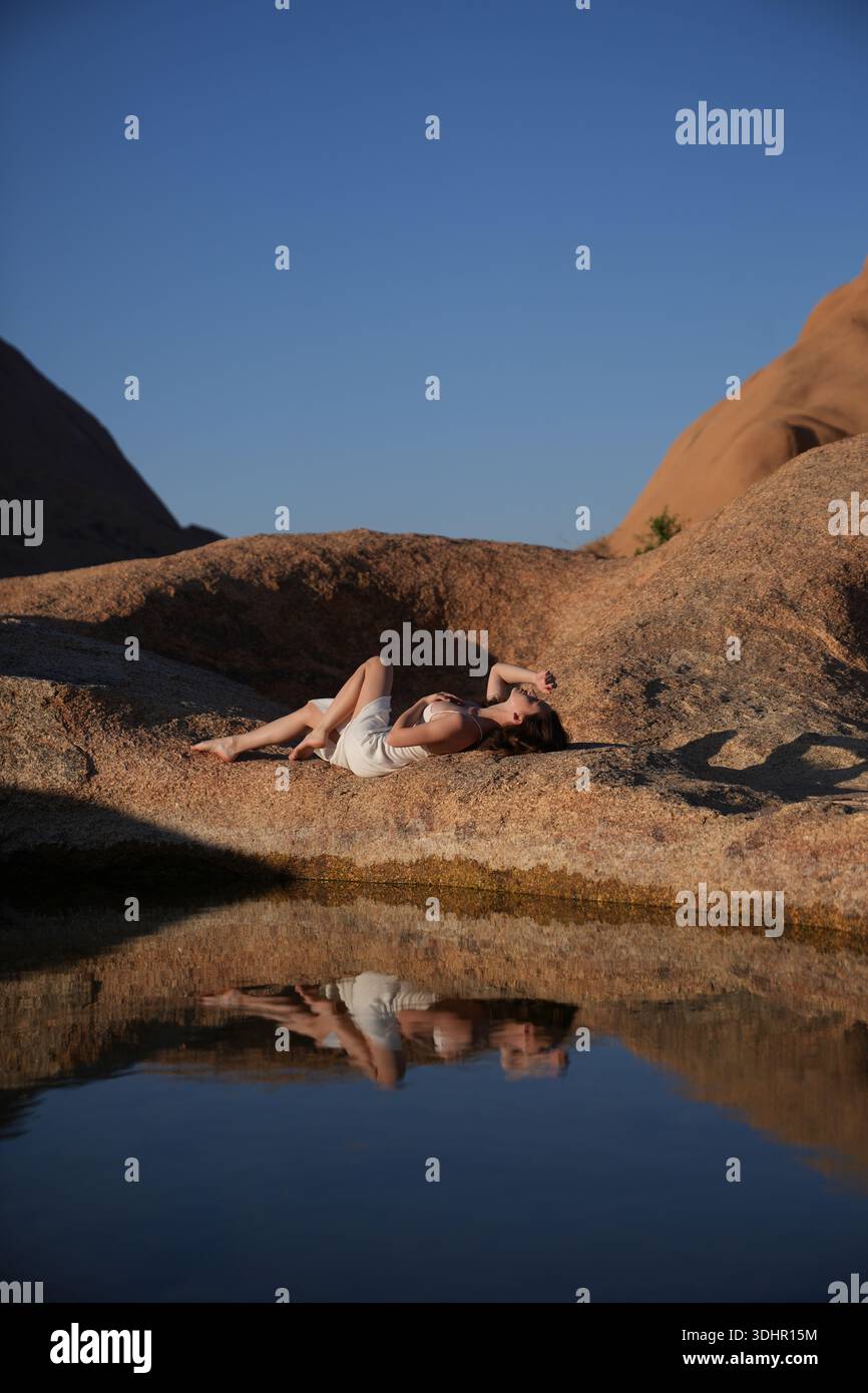Jeunes femmes en robe blanche au lac de réflexion Banque D'Images