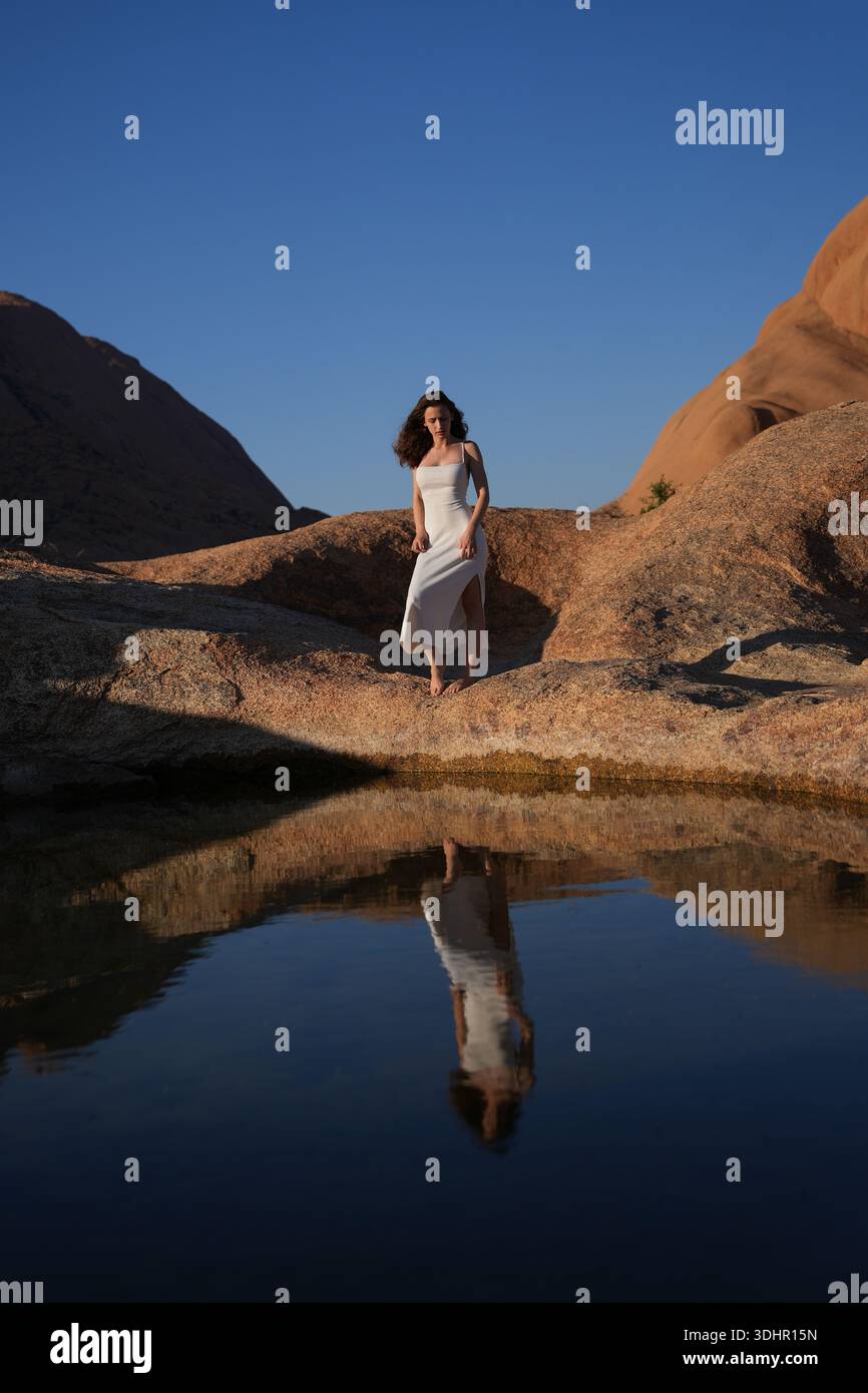 Jeunes femmes en robe blanche au lac de réflexion Banque D'Images