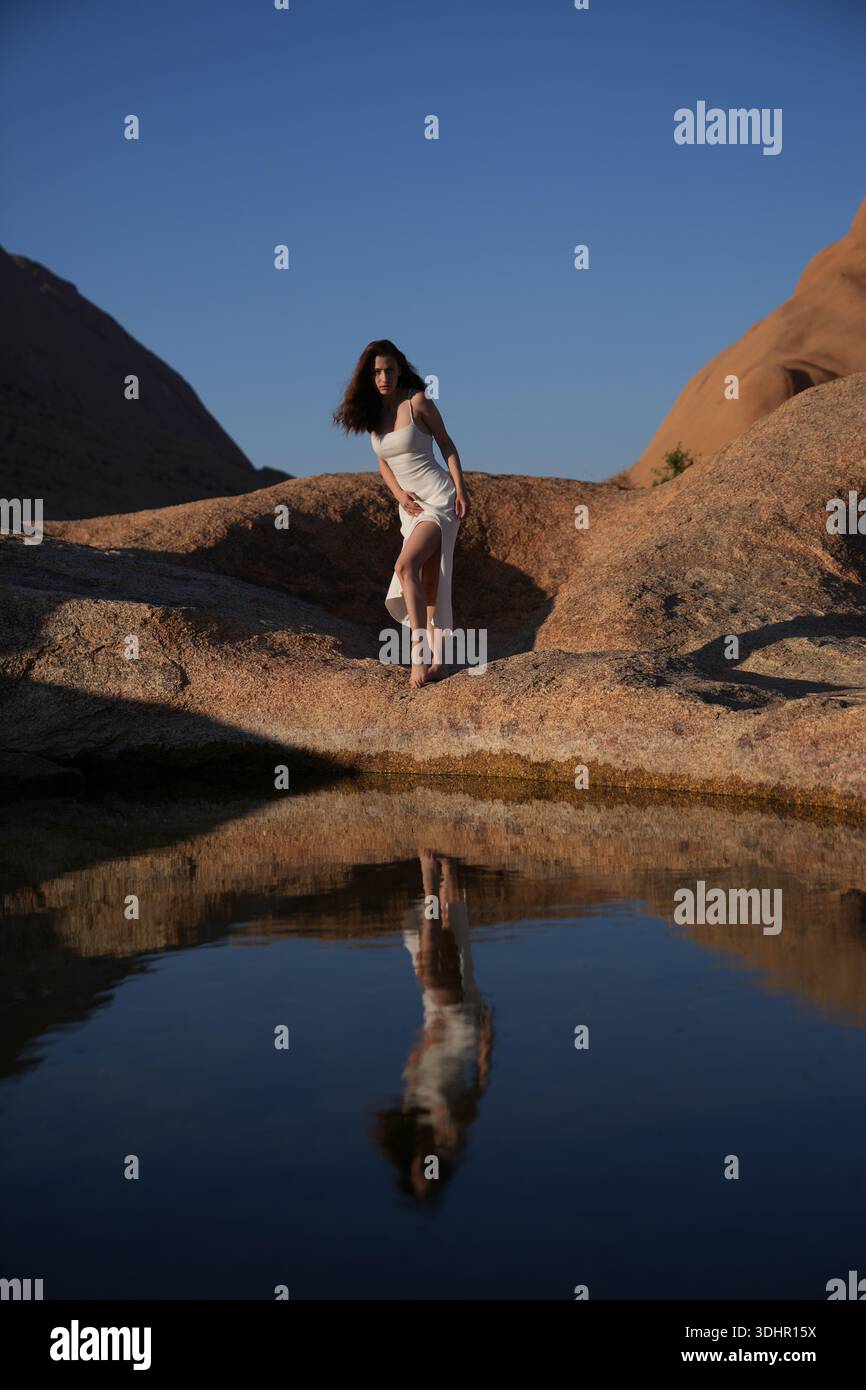 Jeunes femmes en robe blanche au lac de réflexion Banque D'Images