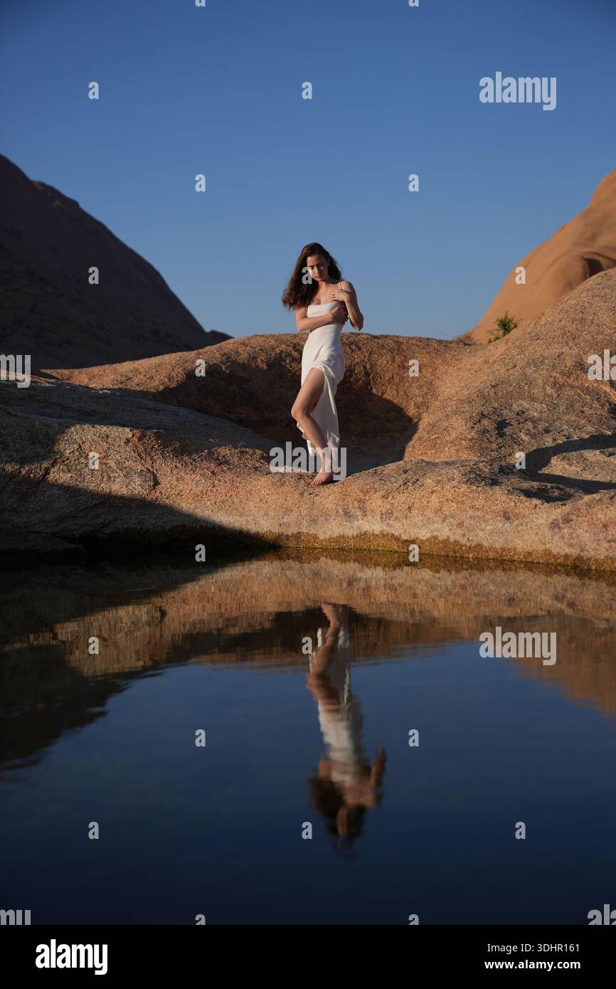 Jeunes femmes en robe blanche au lac de réflexion Banque D'Images