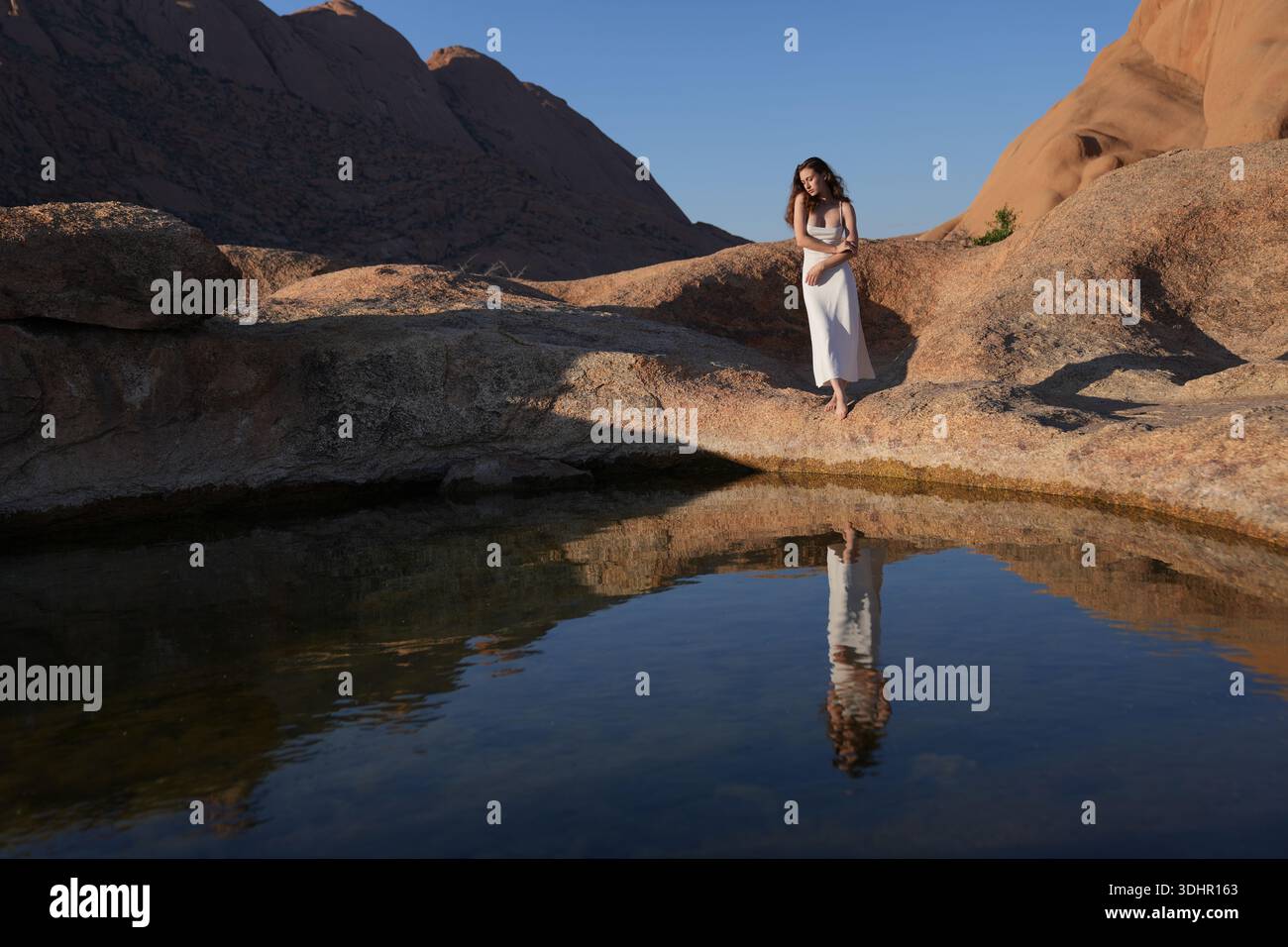 Jeunes femmes en robe blanche au lac de réflexion Banque D'Images