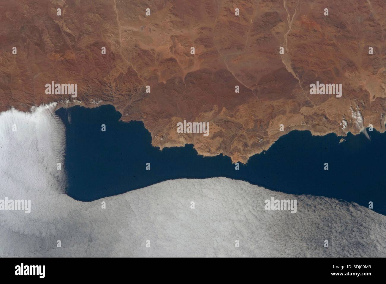 La côte montagneuse de Pan de Azucar, un parc national au Chili, est rencontrée par une nappe de nuages se déplaçant de l'océan Pacifique alors que la Station spatiale internationale montait à 263 miles au-dessus. Le parc national de Pan de Azœcar est un parc national du Chili. Le parc chevauche la frontière entre la région d'Antofagasta et la région d'Atacama. Son nom, Parque Nacional Pan de Azœcar, signifie « parc national du pain de sucre ». Photographie prise depuis la Station spatiale internationale le 16 septembre 2023. Une version optimisée d'une image originale de la NASA : crédit NASA/AMogensen Banque D'Images