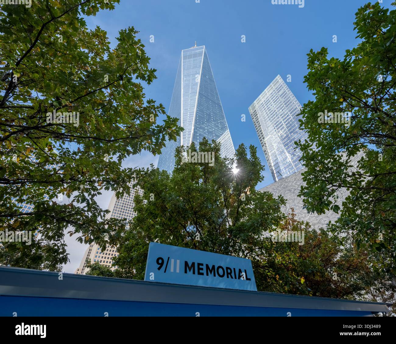 9/11 Memorial Museum signe avec One World Trade Center s'élevant au-dessus de Lower Manhattan, symbolisant le souvenir et la résilience. Banque D'Images