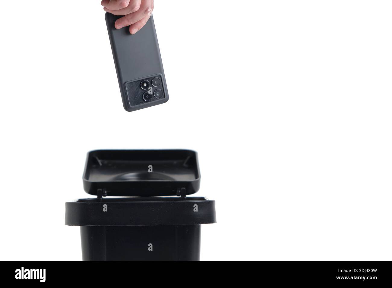 Main de déposer un smartphone moderne dans une poubelle, symbolisant la désintoxication numérique ou l'obsolescence programmée Banque D'Images