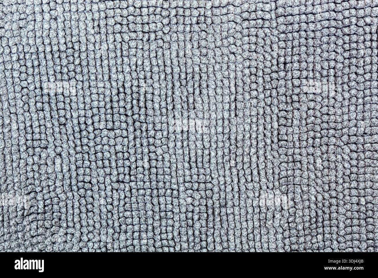 Plan macro d'une surface textile douce avec velours. Fond gris neutre pour la conception montrant une texture confortable de tissu, tapis ou couverture Banque D'Images