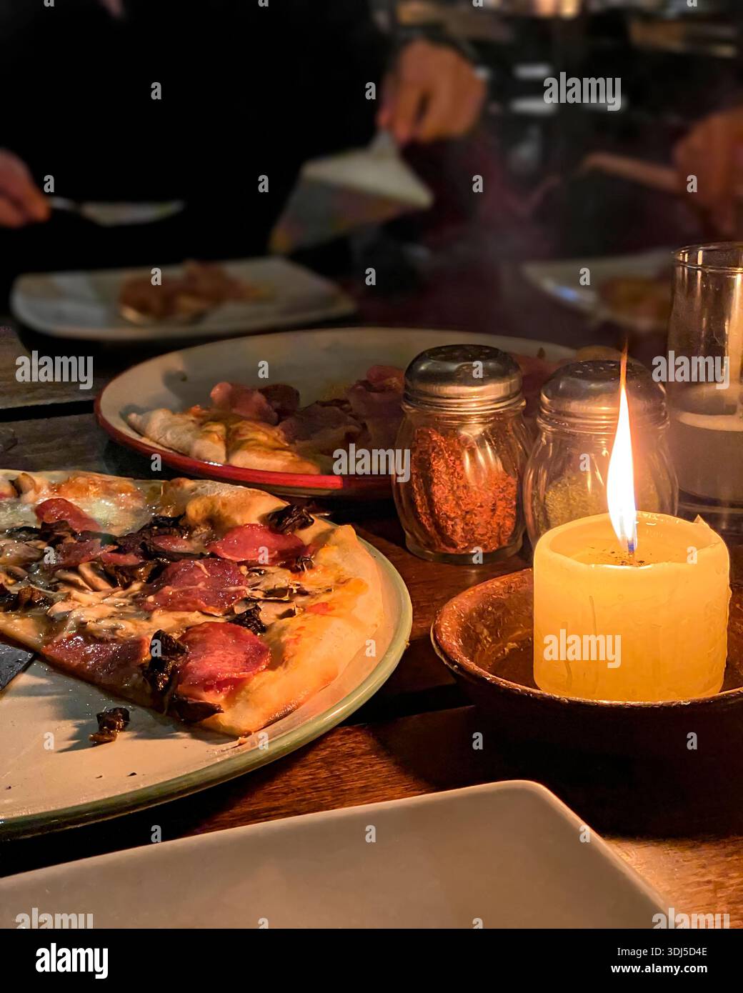 Soirée spéciale avec pizza artisanale dans une ambiance chaleureuse aux chandelles - Image de stock capturée avec un smartphone