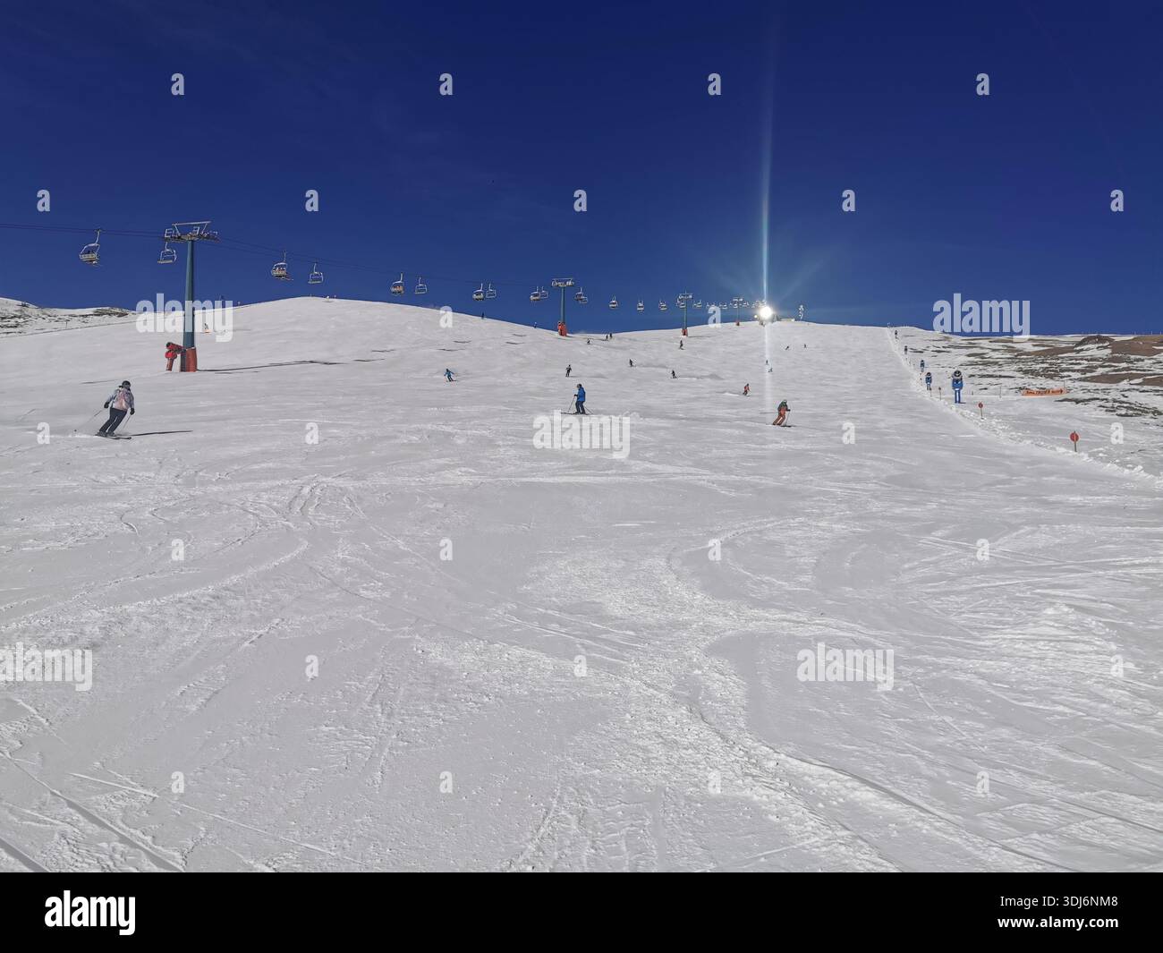 La lumière du soleil se reflète sur la station supérieure du télésiège sur la piste rouge de Seceda, Ortisei dans le Haut-Adige (Südtirol), Dolomites, Italie. Banque D'Images