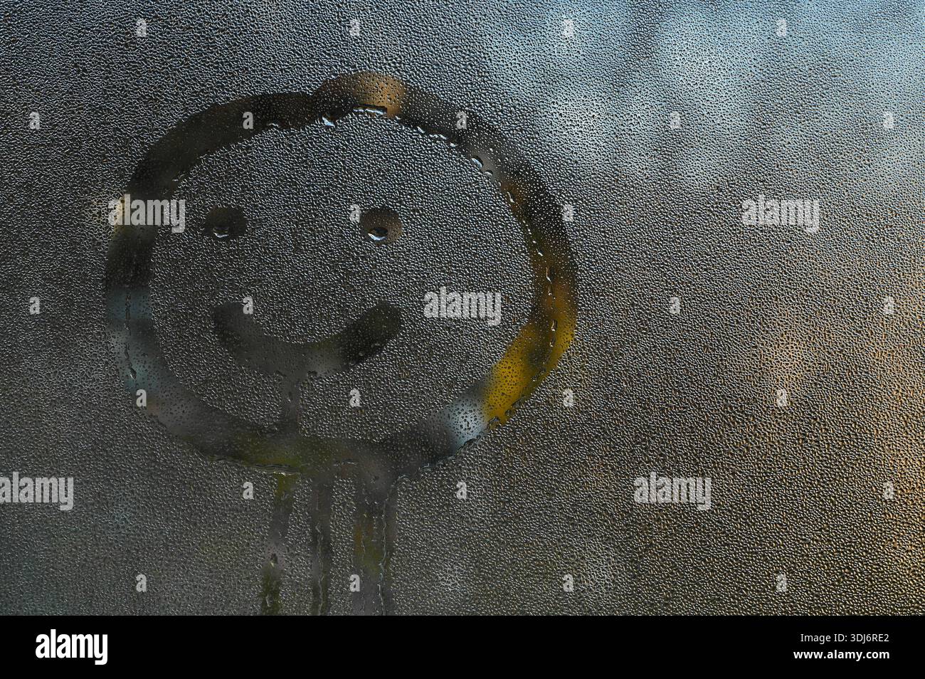 Visage souriant dessiné sur une fenêtre en verre brumeux avec des gouttes d'eau visibles. le dessin d'un visage joyeux transmet l'émotion joyeuse, le toucher humain, le concept météo, un Banque D'Images