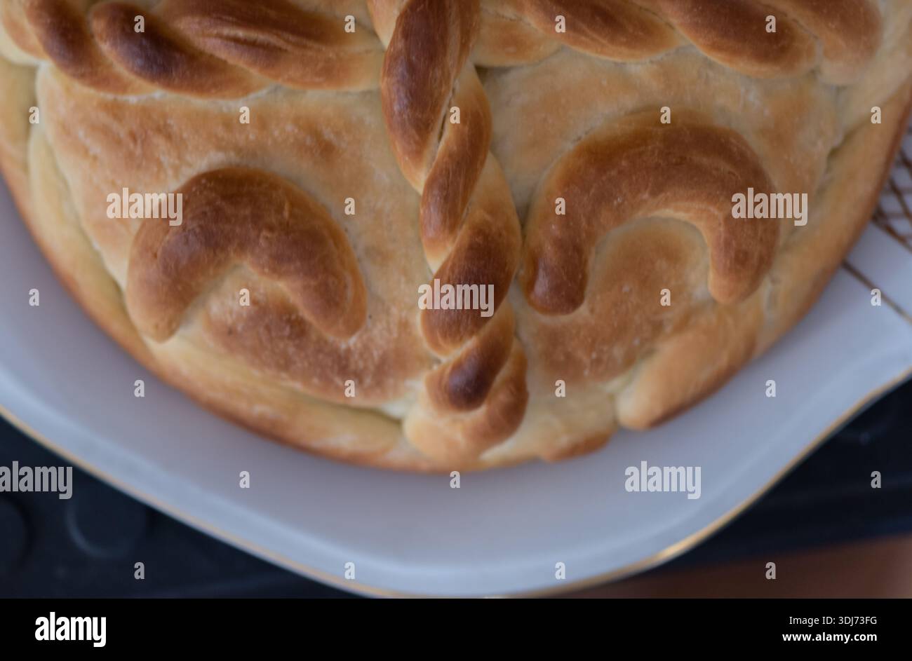 Un demi-pain fait maison avec décoration sur l'assiette blanche. Banque D'Images