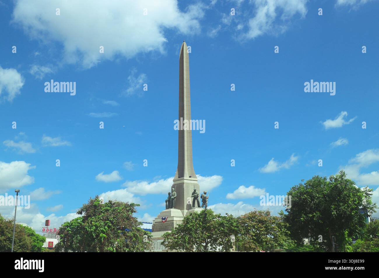 Obélisque Monument de la victoire contre un ciel céruléen à Bangkok. Monument historique thaïlandais et paysage urbain avec des arbres verts. Banque D'Images