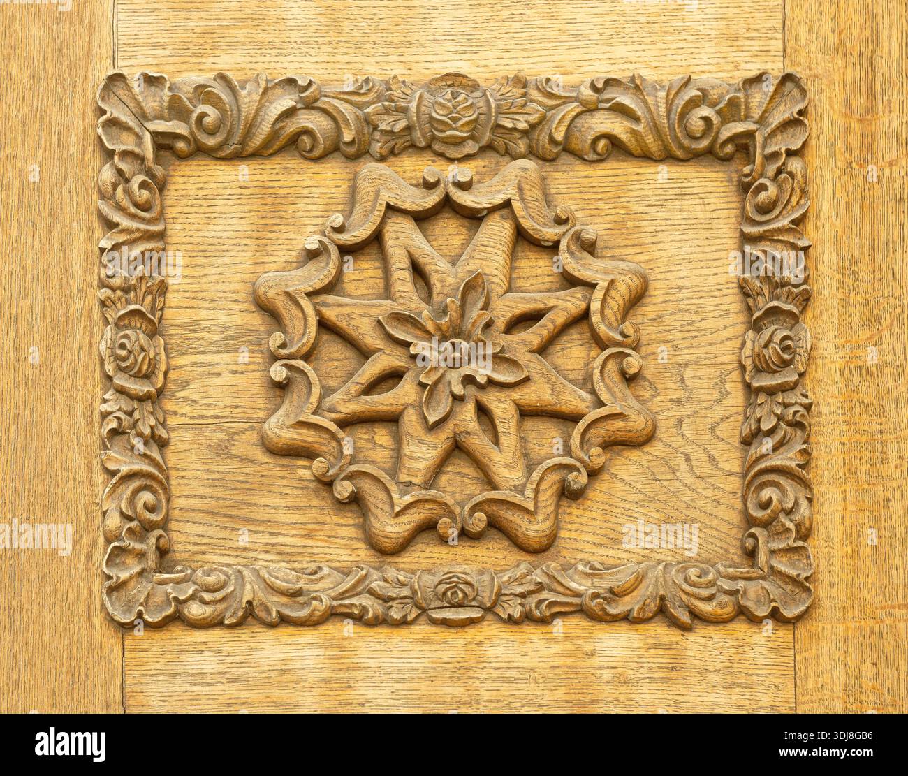 Panneau en bois sculpté à la main complexe avec une étoile centrale entourée d'éléments floraux décoratifs Banque D'Images