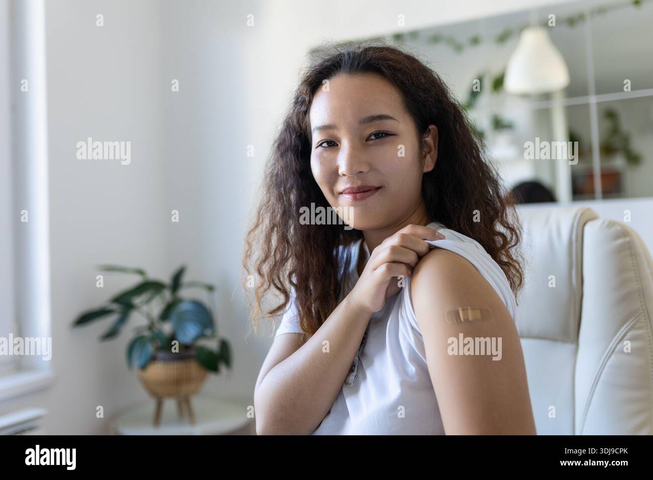 Jeune femme asiatique avec bandage adhésif sur le bras après vaccin contre le virus Corona. Premiers soins. Concept médical, pharmaceutique et de soins de santé. Banque D'Images