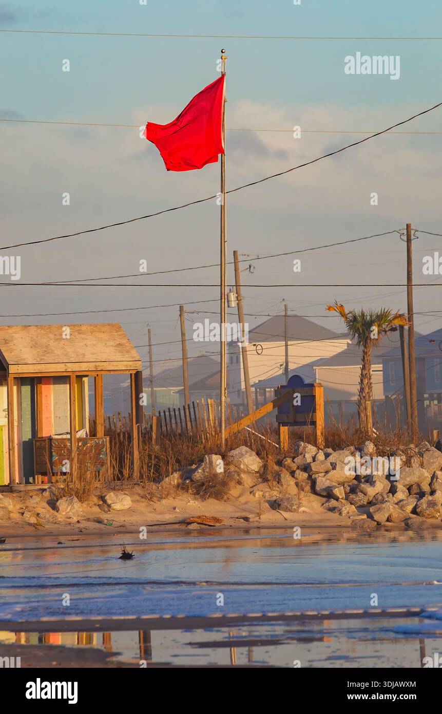 Un drapeau de plage rouge flotte sur le West End de Dauphin Island Alabama. Le drapeau rouge indique des conditions dangereuses. Banque D'Images