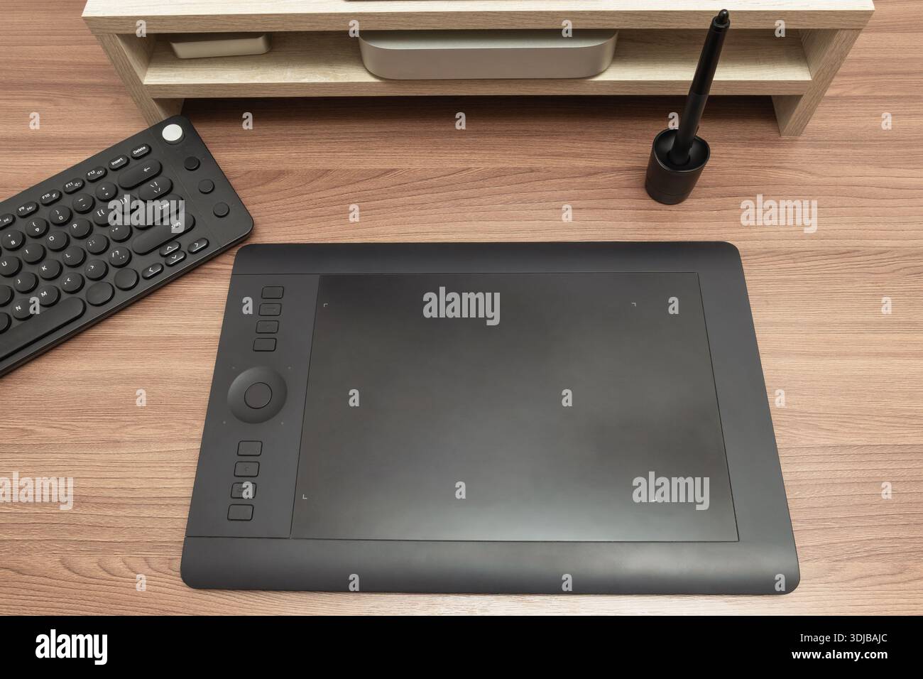 Vue de dessus d'une tablette graphique numérique professionnelle, stylet et configuration du clavier sur un bureau en bois. pour l'art numérique, l'illustration et le graphique d Banque D'Images