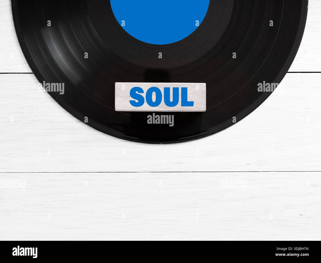Disque vinyle avec une tuile indiquant le genre musical soul reposant sur un fond de bois blanc, représentant le concept de musique et ses genres Banque D'Images