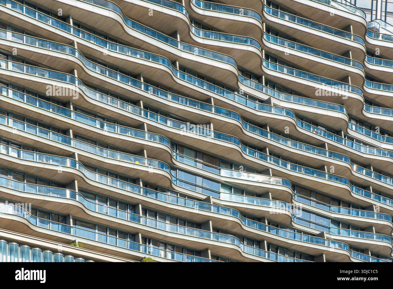 Bâtiment résidentiel moderne avec balcons en verre incurvés, architecture contemporaine et motif géométrique répété dans la ville de Hong Kong, en Chine. Résumé Banque D'Images