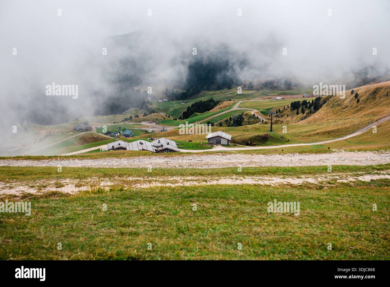 Montagne Seceda avec chalets dispersés et brouillard dans les Dolomites Banque D'Images