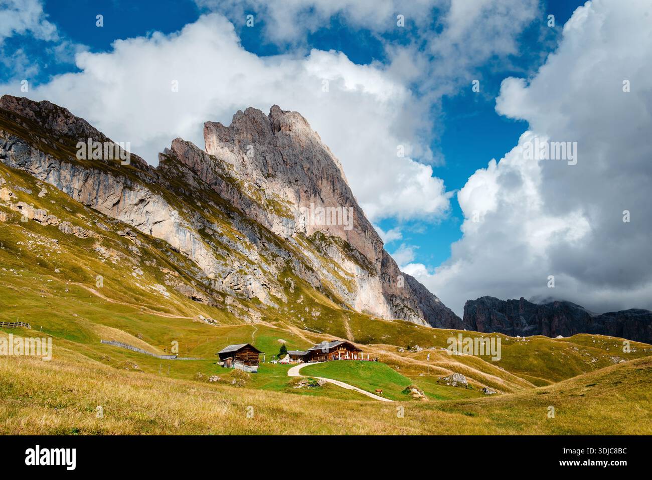 Seceda avec des cabanes alpines traditionnelles et des nuages dans les Dolomites Banque D'Images