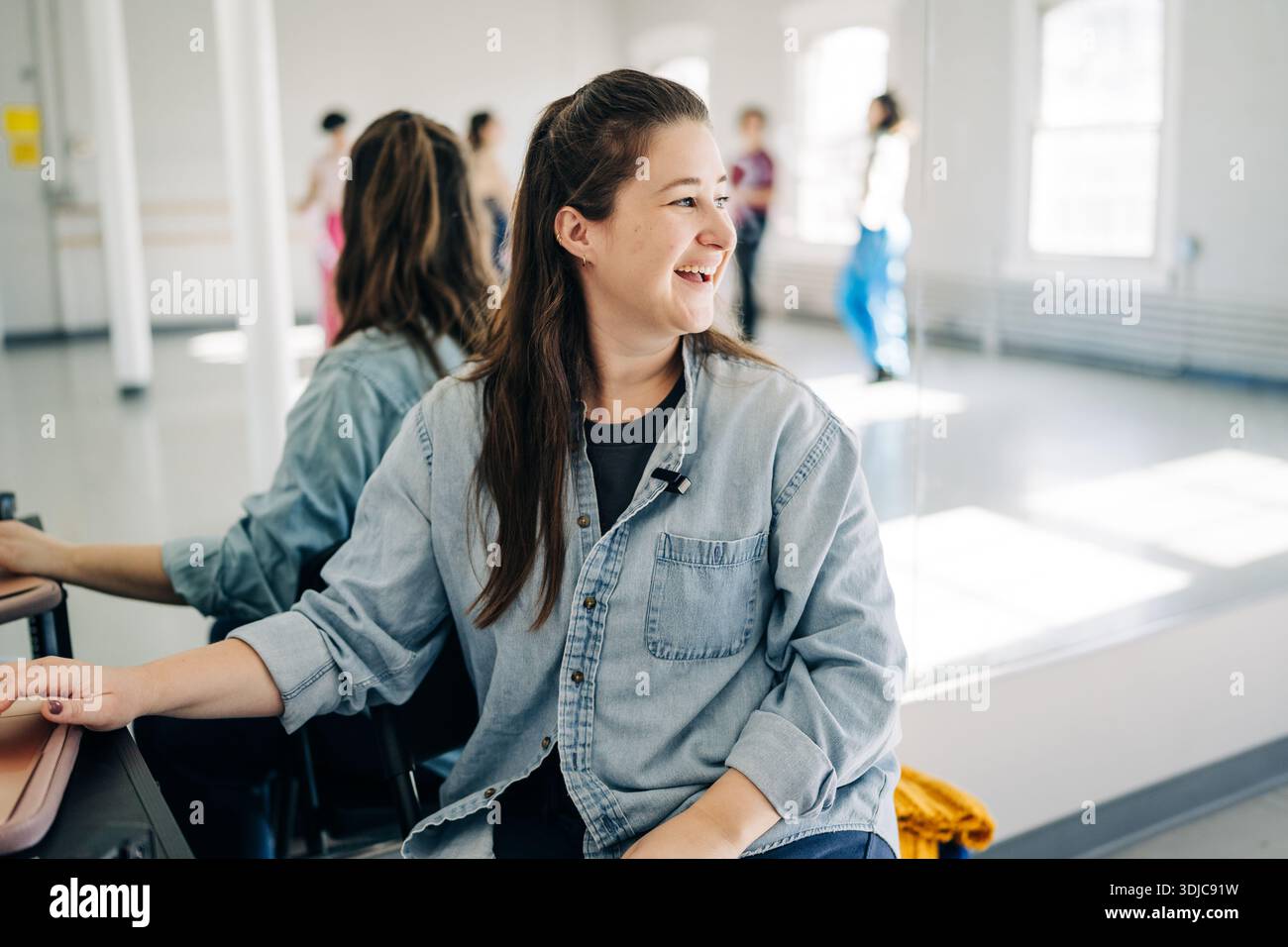 Femme souriante dans un studio de danse reflétant son équipe Banque D'Images