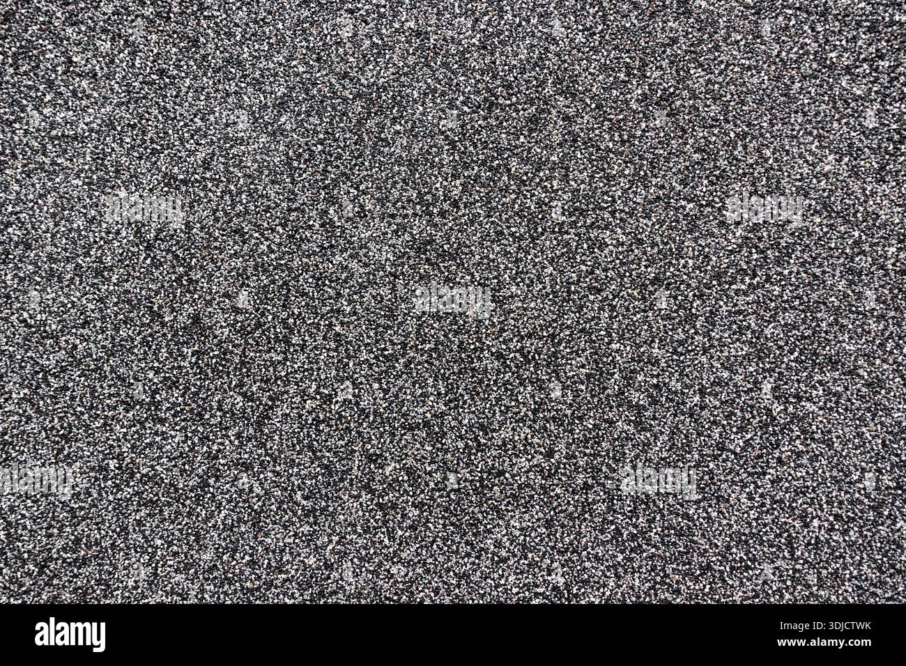 Asphalte granulaire foncé ou surface de gravier avec texture de pierre dense, approprié comme fond industriel abstrait ou de construction Banque D'Images