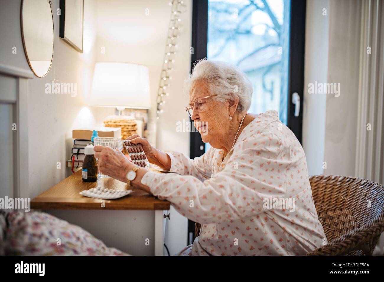 Femme âgée prenant des pilules prescrites après le réveil. Banque D'Images
