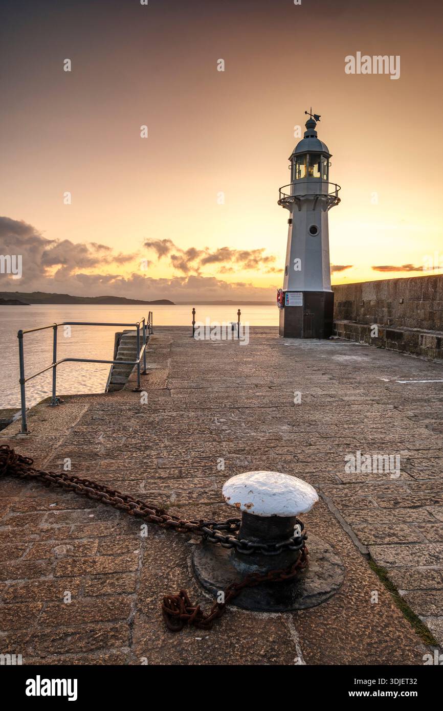 Lever du soleil sur le phare sur le mur du port à Mevagissey, Cornwall Banque D'Images