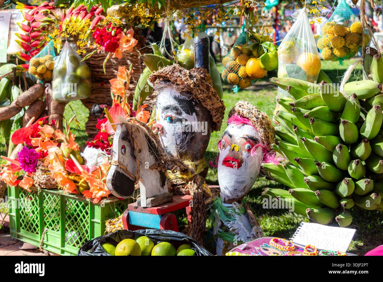 Étal de marché présentant des bananes, divers produits, des fleurs et des poupées d'art populaire Banque D'Images