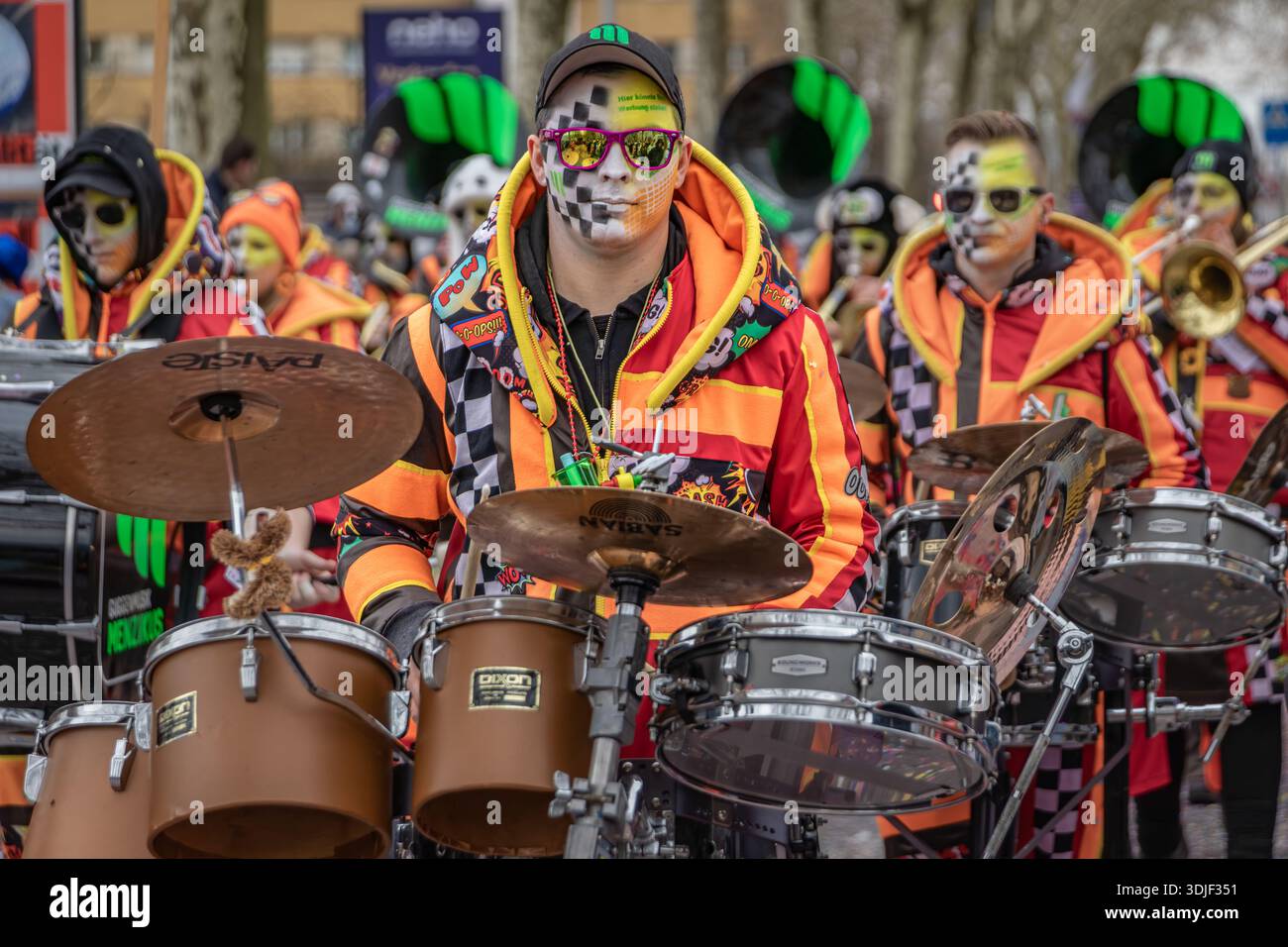 Zug, Suisse - 1er mars 2025 : Guggenmusik marchant une fanfare en costumes colorés et peinture faciale se produit au défilé du carnaval d'hiver de Fasnacht Banque D'Images