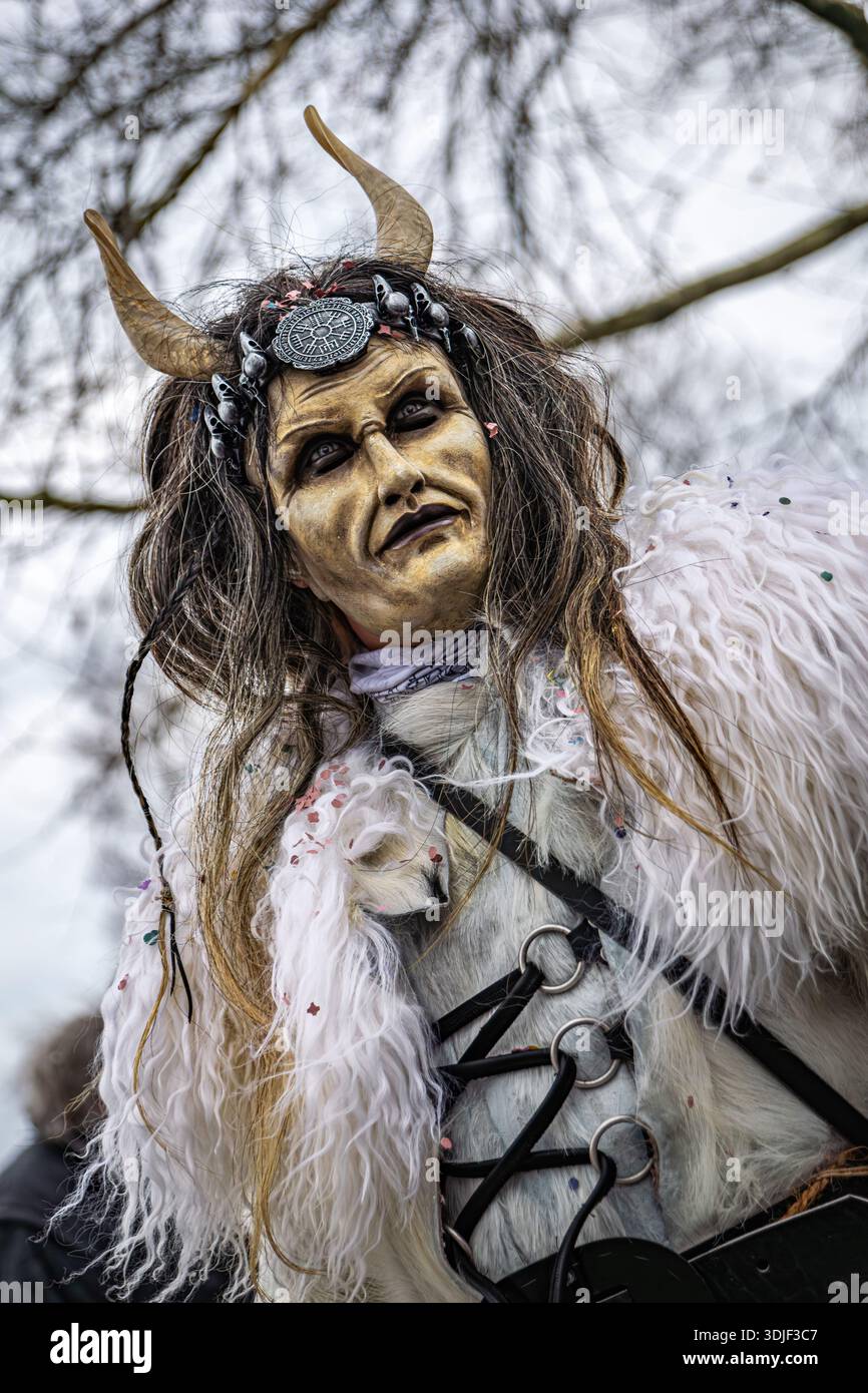 Zug, Suisse - 1er mars 2025 : une personne en costume de bête à fourrure Tschaggatta avec un masque en bois à cornes lors d'un défilé Fasnacht du carnaval d'hiver suisse Banque D'Images