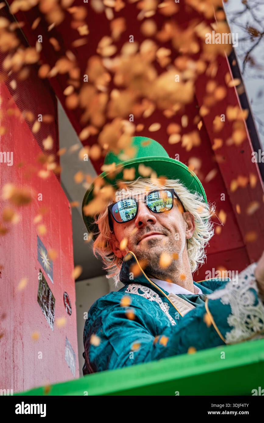 Zug, Suisse - 1er mars 2025 : des confettis brillants flottent dans les airs alors que les fêtards costumés célèbrent le traditionnel défilé du carnaval d'hiver de Fasnacht Banque D'Images