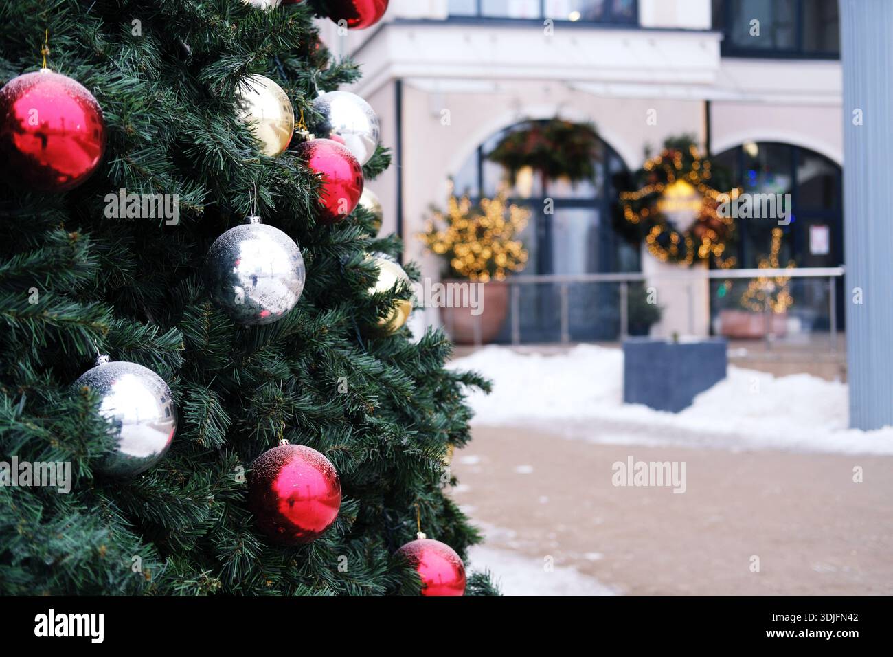 Arbre de Noël décoré avec des ornements brillants se dresse dans un centre commercial, entouré de lumières et de décorations festives, améliorant l'esprit de vacances fo Banque D'Images