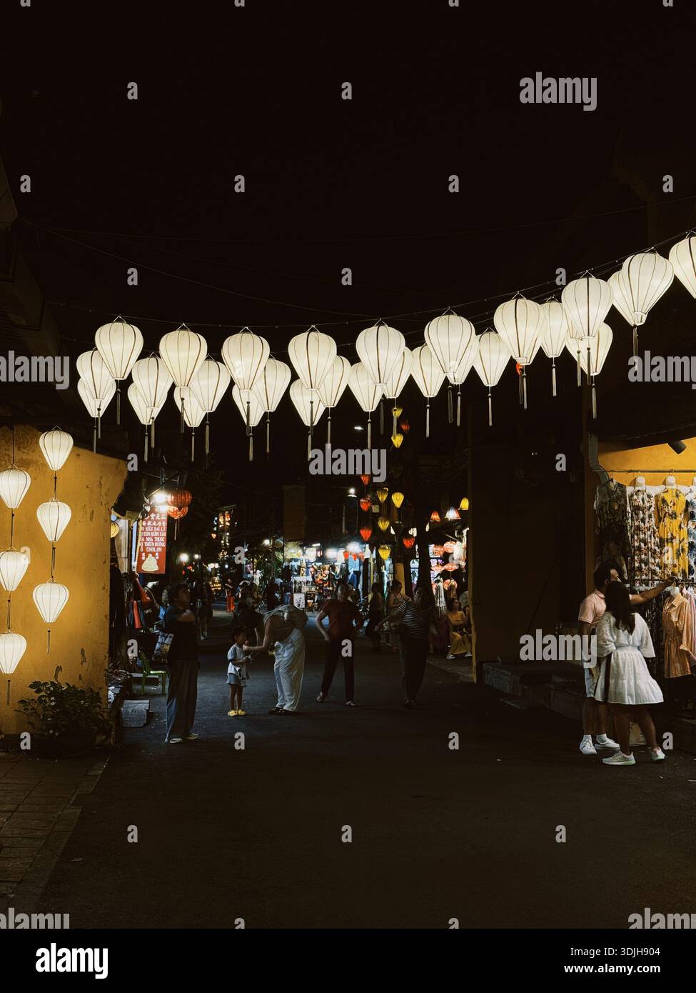 Lanternes traditionnelles illuminant les rues de la ville antique de Hoi an la nuit, Vietnam - Image de stock capturée avec un smartphone