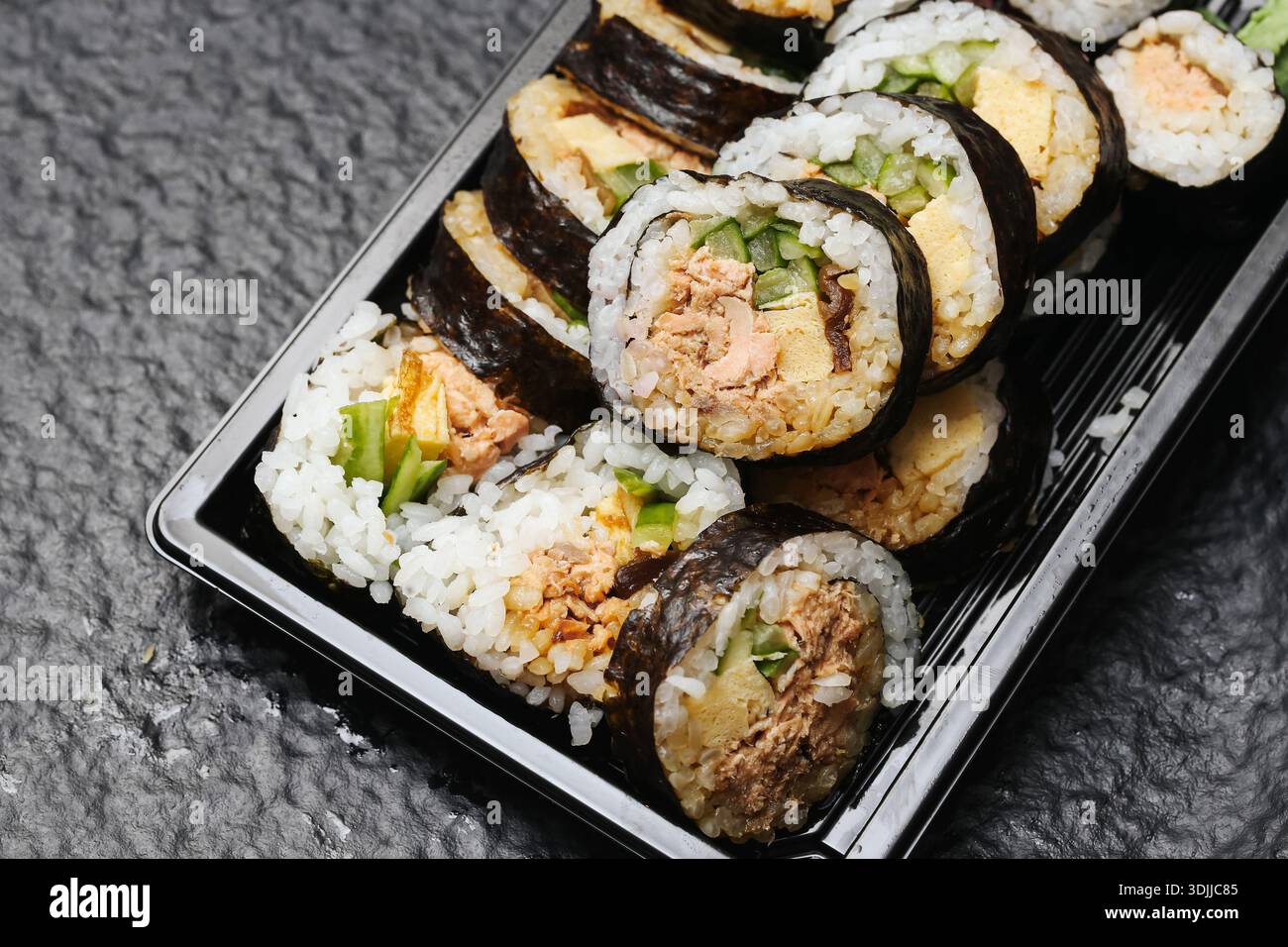 Ensemble de sushis à emporter dans un contenant en plastique gros plan. Rouleaux de nourriture japonais avec riz et poisson. Concept de livraison de cuisine asiatique prêt à manger. Banque D'Images