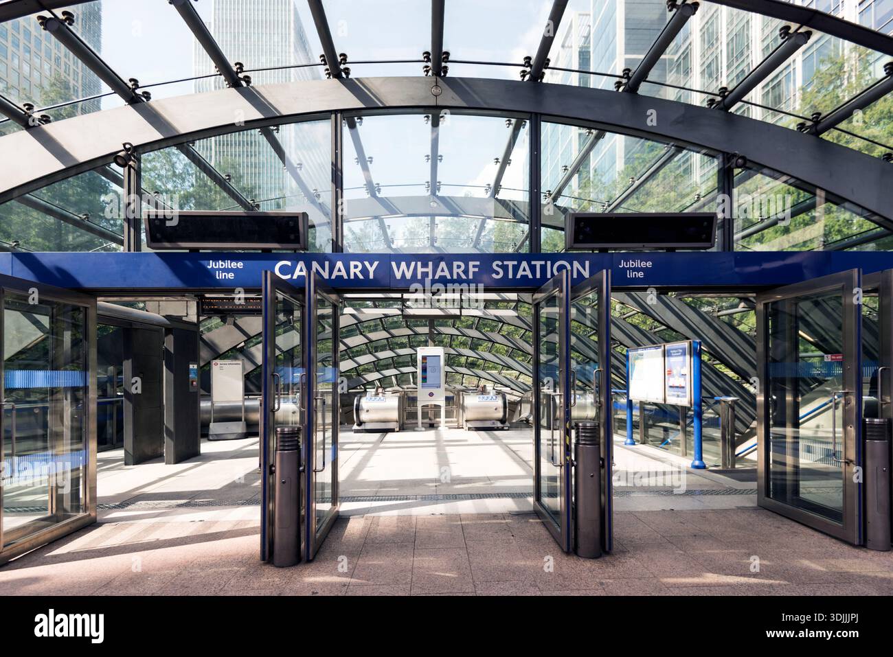 Une vue large de l'entrée moderne en verre et en acier de la station de métro Canary Wharf, montrant la symétrie architecturale et la ligne Jubilee Banque D'Images