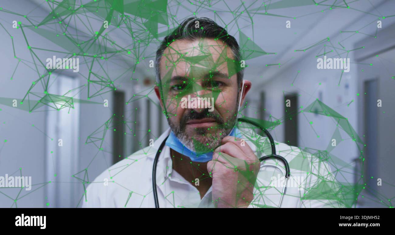 Médecin debout en blouse de laboratoire et stéthoscope dans le couloir médical, touchant le masque bleu sous AR vert Banque D'Images