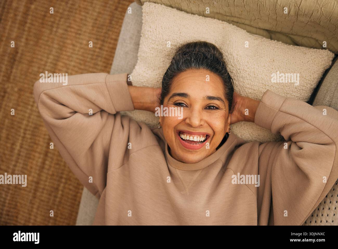 Directement au-dessus du plan de la femme mature heureuse couchée sur le canapé à la maison Banque D'Images