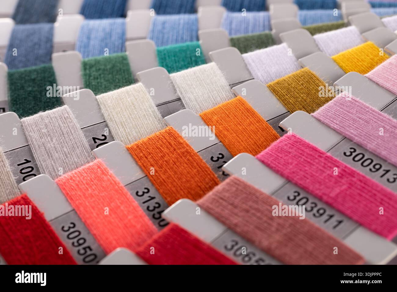 Une vue en gros plan, en grand angle, montre un tableau organisé d'échantillons de carton rectangulaires enveloppés dans différents fils de couleur, chacun marqué d'un i noir Banque D'Images