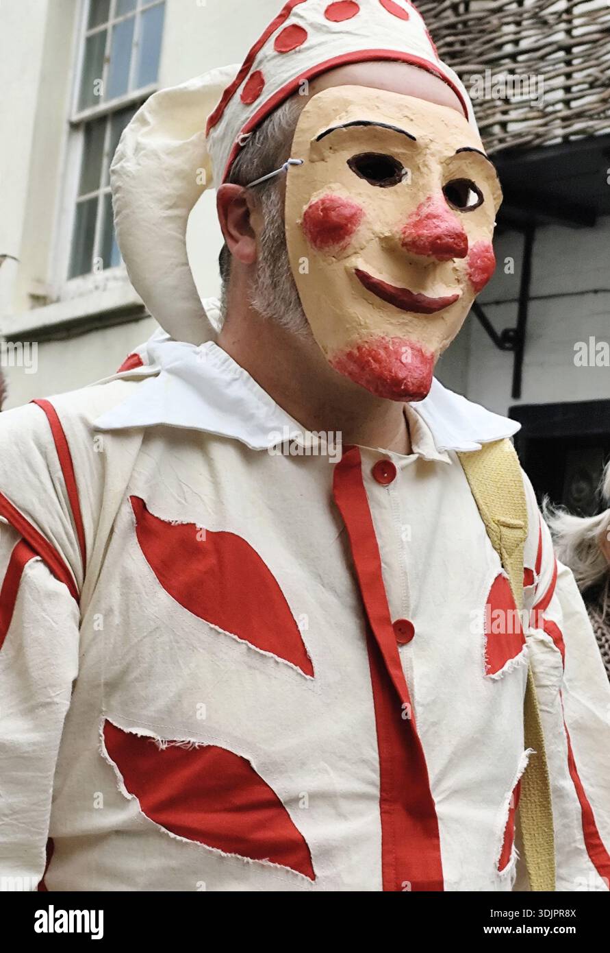 Un participant portant un costume d'arlequin rouge et blanc et un masque au festival Jack in the Green, Hastings, East Sussex, Royaume-Uni Banque D'Images