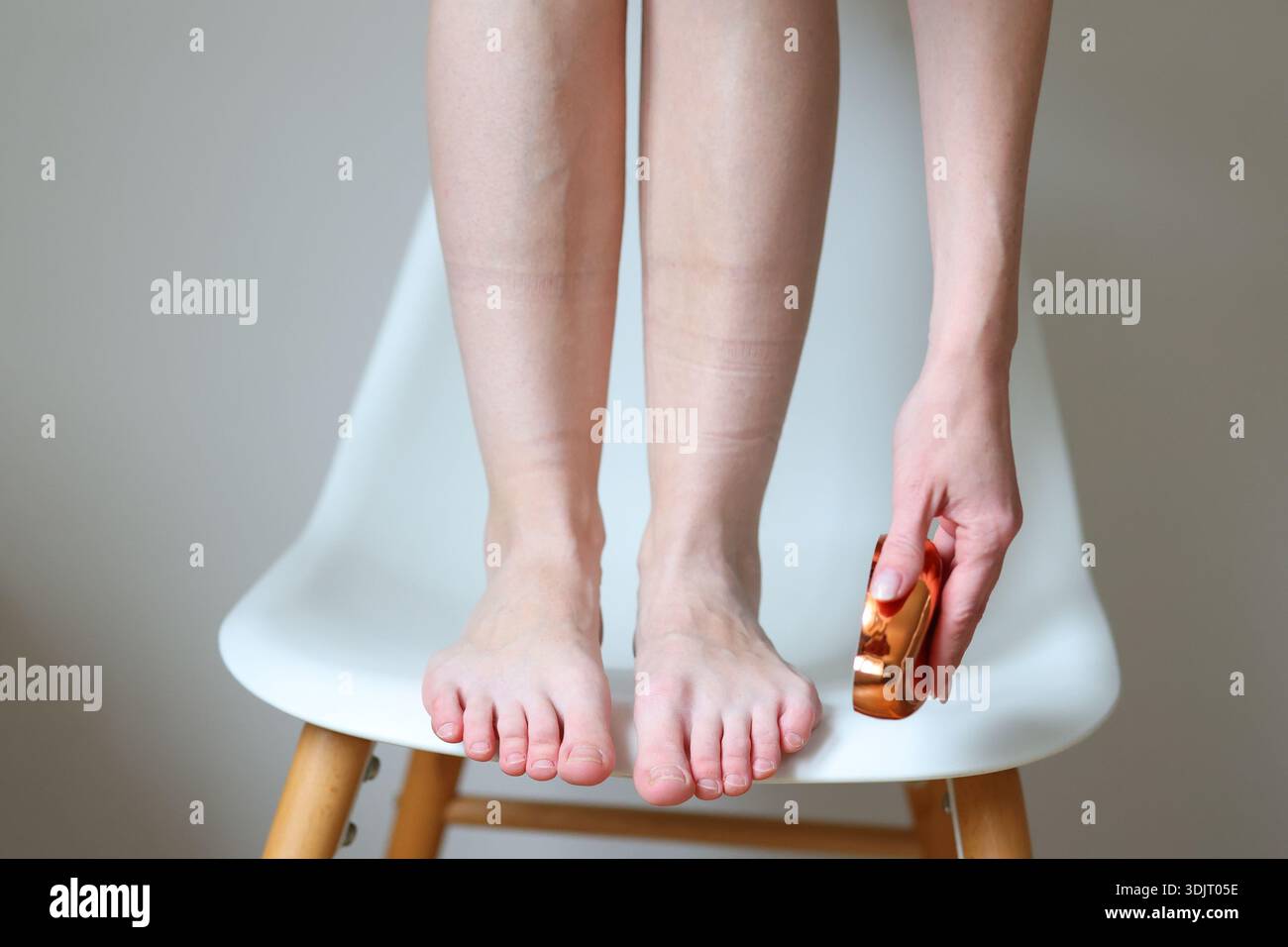 pied féminin utilisant une lime pédicure pour le soin du talon et la routine de soin de la peau à domicile Banque D'Images