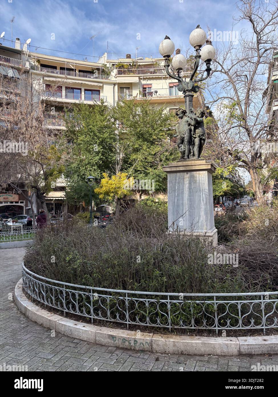 Place Agios Georgios, Πλατεία Αγίου Γεωργίου Κυψέλης, Kypseli, Athènes, Grèce. Place urbaine ornée d'un lampadaire orné et d'une statue en bronze. Banque D'Images