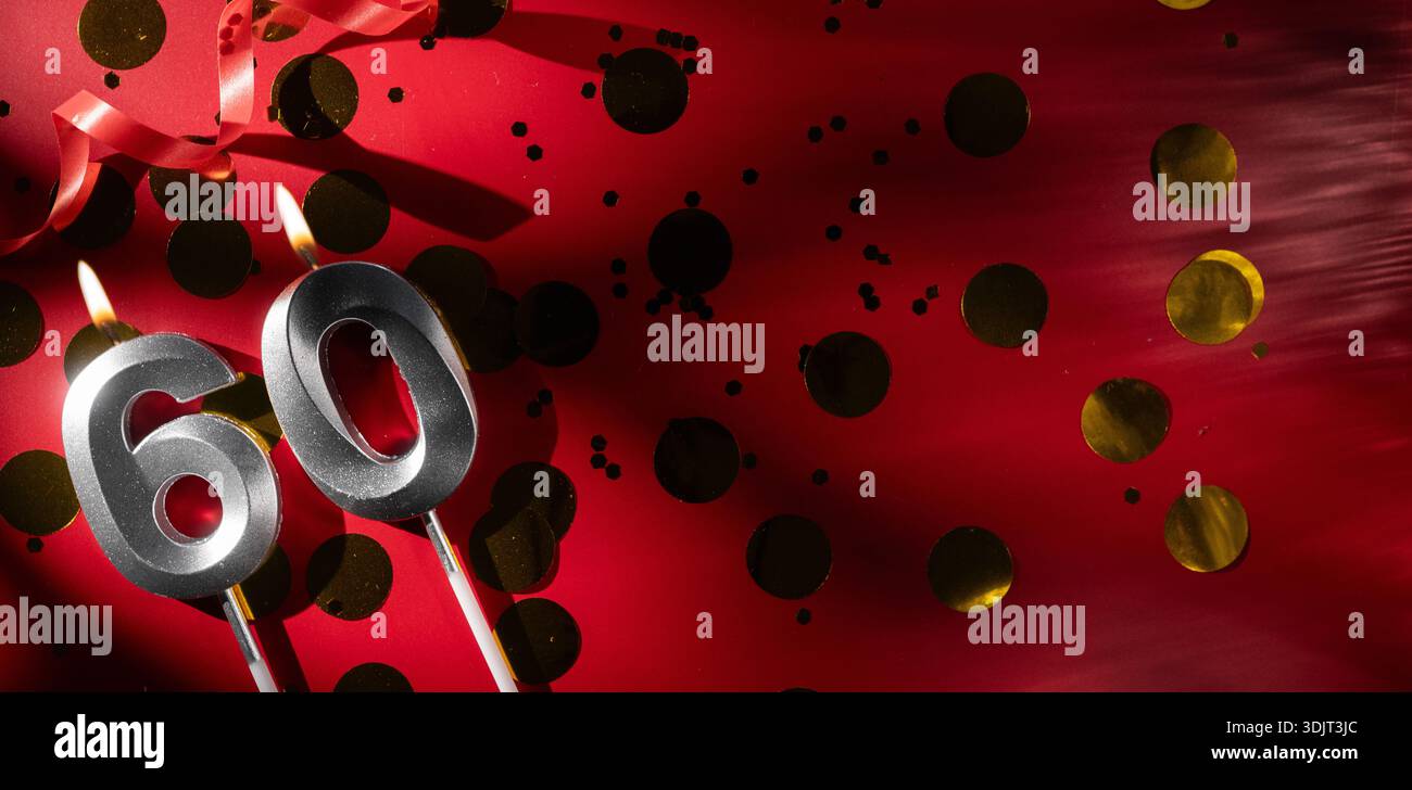 Concept de célébrer l'anniversaire et l'anniversaire. Numéro 60 soixante bougie d'anniversaire de célébration en argent sur fond rouge festif avec grand confet doré Banque D'Images