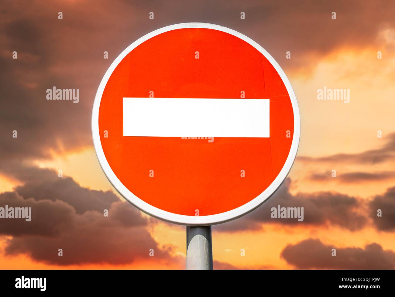 Panneau rond stop, pas de panneau d'entrée sur fond d'un ciel cramoisi alarmant Banque D'Images