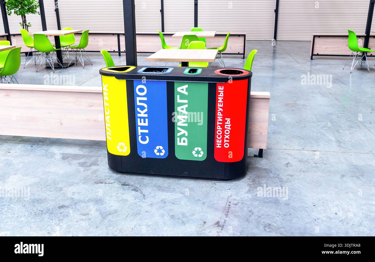 Récipients multicolores en plastique pour la collecte séparée des déchets. Séparez les poubelles en fonction du type de déchets. Texte en russe : plastique, verre Banque D'Images