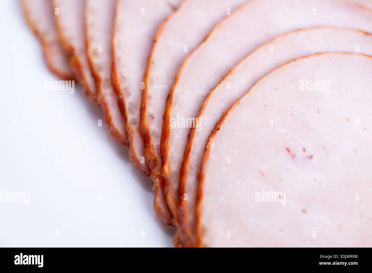 Couche de jambon sandwich gourmet en gros plan, tranches fines et même avec bord fumé, évoque la préparation du déjeuner de qualité supérieure et la sélection des ingrédients du chef pour les hommes de sandwichs artisanaux Banque D'Images