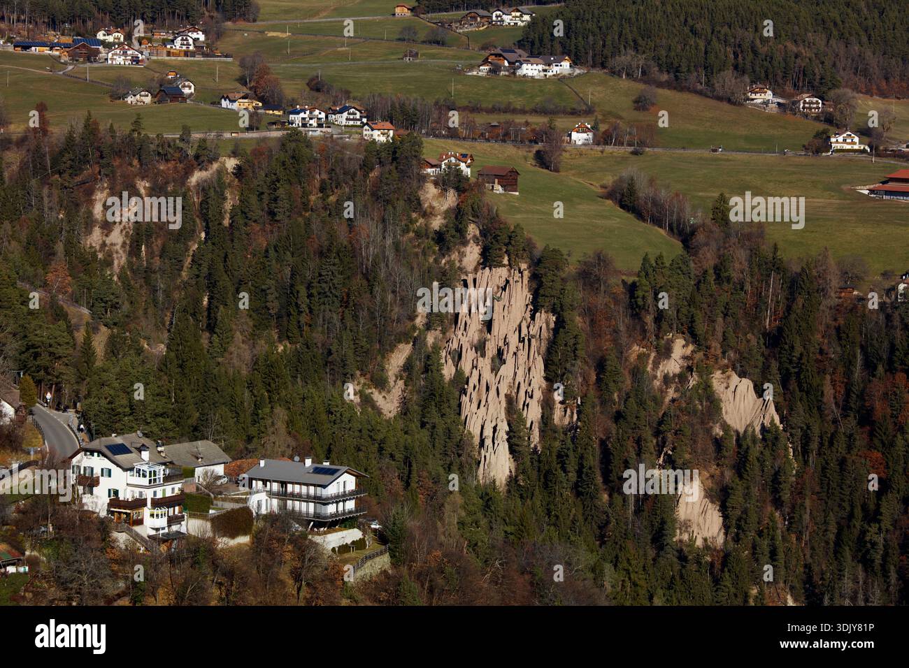 Un hôtel et des maisons près des pyramides de la Terre de Ritten (Renon), un monument naturel situé sur un plateau près de Klobenstein dans le Tyrol du Sud, Italie. Banque D'Images
