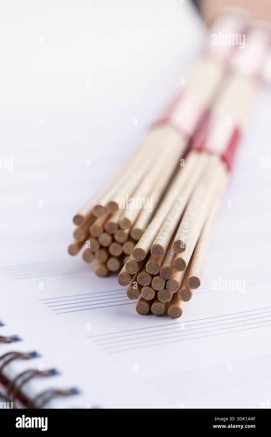 Hot rods pour batteurs sur des feuilles de musique, feuille rouge vif Banque D'Images