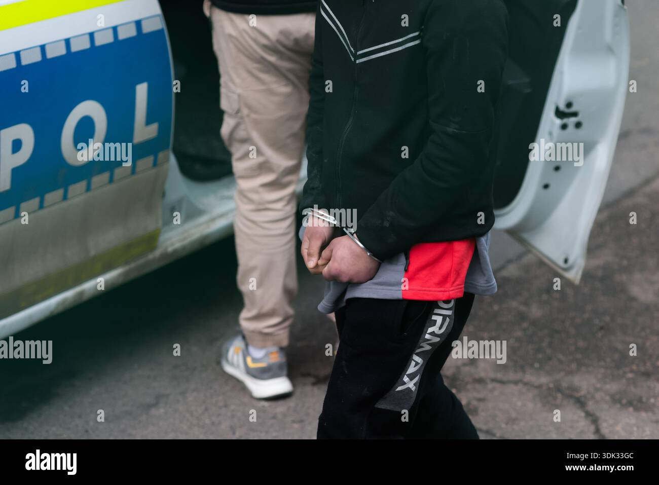 Bucarest, Roumanie - 29 janvier 2026 : Détails avec un homme menotté arrêté par des policiers roumains. Banque D'Images