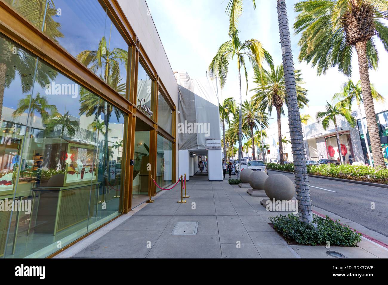 Beverly Hills, Californie - 21 janvier 2026 : emblématique Rodeo Drive à Beverly Hills présentant les vitrines Cartier et Louis Vuitton avec des palmiers signature Banque D'Images