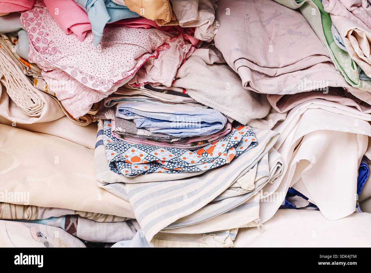 Pile de vêtements pliés empilés après le linge à la maison. Textiles propres préparés pour le stockage et l'organisation. Gestion des vêtements ménagers. Banque D'Images