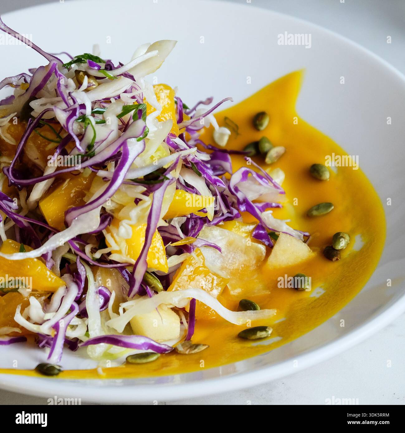 Chou à la mangue gourmet plaqué dans un bol en céramique blanche Banque D'Images